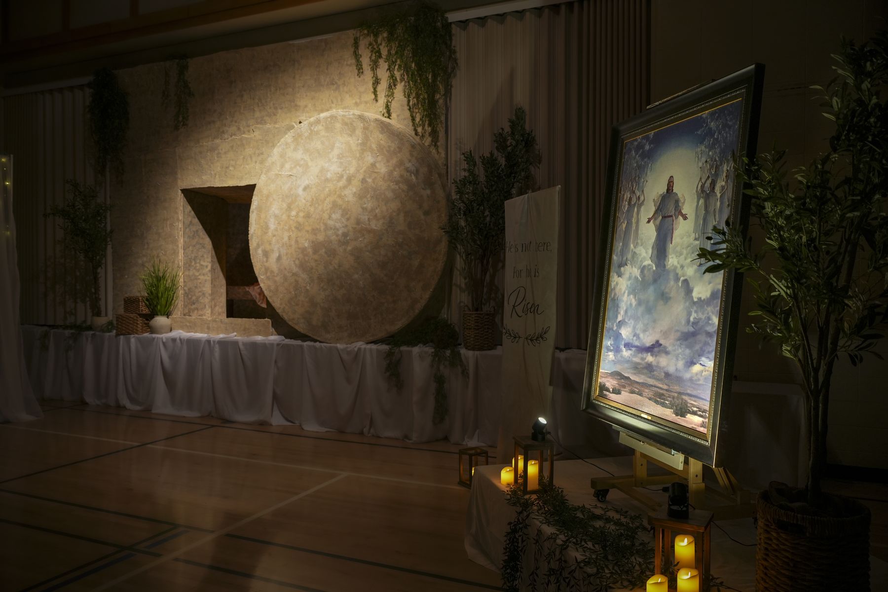 The open tomb from last year's exhibit, its round stone rolled aside, lit by one warm light.